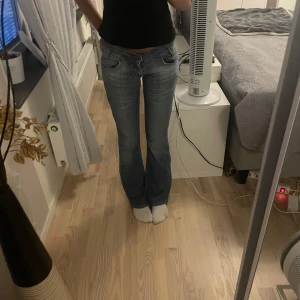 Blå lågmidjade bootcut jeans från Lee - Snygga blå jeans från Lee med bootcut-modell och klassisk femficksdesign. Jeansen har en lätt tvättad look och är tillverkade i slitstarkt denim. Perfekta för dig som gillar en tidlös och avslappnad stil.