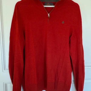 Röd 1/4 zip merinoullströja från Morris - Snygg röd tröja från Morris i mjuk merinoull. Modellen har half zip-dragkedja vid halsen och diskret logga på bröstet. Säljer den då den inte passar mig längre. Sitter väldigt snyggt i passform samt har en stilren röd färg.