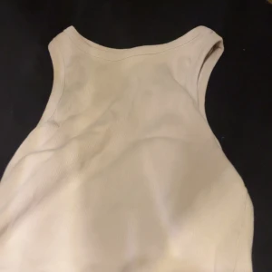 Beige ribbad linnetopp - Snygg beige ribbad linnetopp med rund halsringning. Perfekt för lager-på-lager eller att bära som den är. Enkel och stilren design som passar till allt. Mjuk och stretchig känsla.