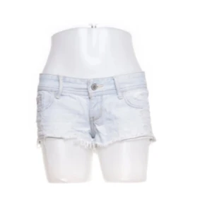 Ljusblå jeansshorts - Säljer ett par ljusblå jeansshorts i en avslappnad stil. De är lågmidjade med slitna detaljer och fransar vid benen för en cool look. Perfekta för sommardagar eller festivaler. Passar bra till en enkel topp eller linne. Skicka ett meddelande vid intresse! Midjemåttet är ca 39-40cm rakt över ❤️