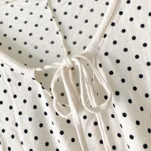 🍒Vit prickig topp med knyt🍒 - 🍒SOFT TOUCH🍒Supersöt vit topp med svarta prickar och knyt framtill vid halsen. Blusen har korta, lite lösa ärmar och en avslappnad passform.  Kommer i ett mjukt material som Ginas soft touch kollektion. 🍒