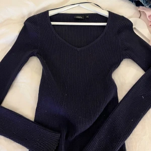 Mörkblå ribbad stickad tröja V-ringad - Säljer en mörkblå stickad tröja från Kappahl. Sitter tajt. 