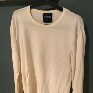 Vit stickad tröja från Peak Performance - En stilren vit stickad tröja från Peak Performance i storlek L men det funkar för M också. Tröjan har rund halsringning och långa ärmar, perfekt för lager-på-lager. Enkel och clean design som funkar till det mesta. Materialet känns mjukt och skönt mot huden.