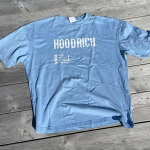 Ljusblå Hoodrich t-shirt XS - Säljer en ljusblå t-shirt från Hoodrich i storlek XS. T-shirten har tryck både fram och bak med texten 'Hoodrich' och 'From nothing to something'. Klassisk passform med korta ärmar och rund hals. Perfekt för dig som gillar streetwear vibes. Nypris 350kr