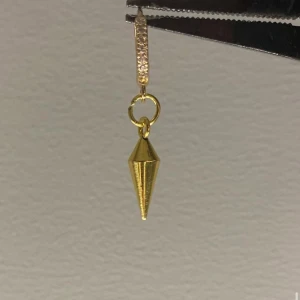 Guldigt örhänge med konformad hängare - Stilrent örhänge i guldton med glittrig ring och en konformad hängare. Perfekt för dig som gillar minimalistiska smycken med en cool twist. Passar till många olika looks och ger en snygg detalj till din outfit.