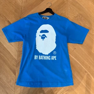 BAPE t-shirt - Säljer denna feta BAPE t-shirt i en unik blå färg. Tröjan är endast använd ett fåtal gånger och är därför i väldigt bra skick. Nypris är runt 3000kr. Självklart äkta. Den är i storleken S, men är oversize och passar därför även M. Pris kan diskuteras