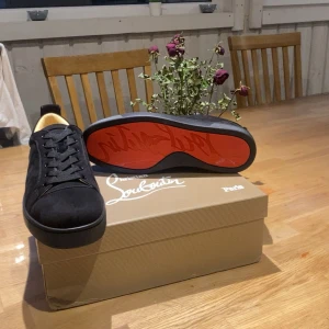Christian Louboutin  - Säljer ett par exklusiva Christian Louboutin sneakers i storlek 43. Stilrena och tidlösa i helsvart mocka. Snabbt köp= bättre pris. Skriv vid funderingar  