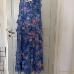 Blå och rosa långklänning med volanger - Superfin långklänning ifrån bohoo, storlek 42 men passar mig som oftast har 40🩷 använd enstaka gånger, går ända ner till marken på mig som är 168🩷