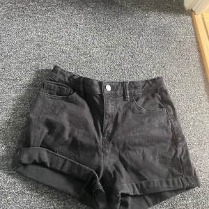 Svarta shorts från Lindex - Snygga svarta shorts från Lindex i en klassisk design. De har en hög midja och uppvikta ben för en trendig look. Perfekta för sommardagar! Använt få gånger, otroligt bra skick!