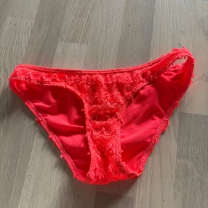 Rosa bikiniunderdel från NLY Beach - Säljer en snygg rosa bikiniunderdel från NLY Beach i storlek S. Bikinin är dekorerad med spetsliknande broderade detaljer och är tillverkad i 100% polyester. Perfekt för sommardagar vid stranden eller poolen! Hann aldrig komma till användning 