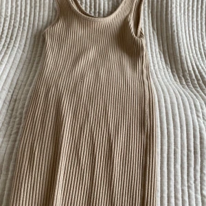 Beige ribbad långklänning - Säljer min tajta beigeribbade klänning i jättebra skick! Funkar också som en kjol, se bild. 