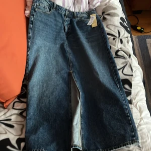 Blå jeanskjol från Index - Snygg blå jeanskjol från Index i en klassisk design. Kjolen har en rak passform med två bakfickor och en slits framtill för extra rörelsefrihet. Perfekt för en avslappnad stil.