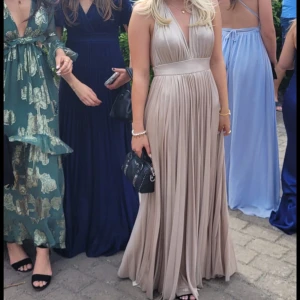 Guldig balklänning  - Säljer världens finaste och elegantaste balklänning, den har en v-ringning i fam och en öppen rygg. Den perfekta klänningen till studentbalen, 9:ans bal eller andra festliga tillfällen. Den är endast använd en gång och är i perfekt skick!