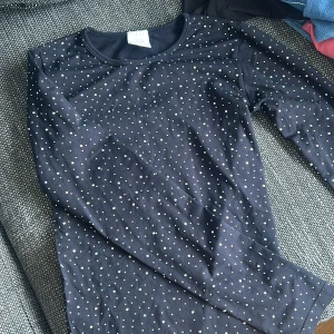 Svart långärmad topp med glittriga prickar från Zara - Säljer en svart långärmad topp från Zara med glittriga prickar över hela tröjan. Perfekt för dig som vill ha något enkelt men ändå med lite extra bling. Mjuk och skön bomullskänsla.