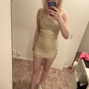Glittrig klänning  - Från dressy inga fel på den fin med öppen rygg glittrar fint men säljer då ja fick den i fel färg å inte gick att skicka tillbaka 