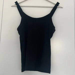 Svart ribbat linne - Ett svart ribbat linne från Gina Tricot. Lite bredare axelband. Använd max 5 gånger. Storlek S. 20kr