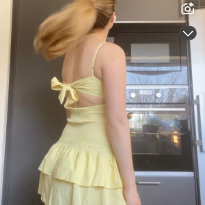 Gul rutig volangklänning med rosett i ryggen - Söt gul kortklänning med rutigt mönster och volanger. 💛