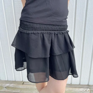 Svart volangkjol - Säljer en svart kortkjol med dubbla volanger. Modellen på bilden har vikt ner kanten men man kan såklart ha den uppvikt också! Skriv vid fler bilder, frågor eller prisförslag! Köp gärna flera varor i samma order! 😊💕