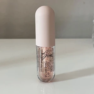 Läppglans - Säljer ett plumping lip gloss från Åhléns med skimrande glittereffekt. Färgen är transparent med inslag av guldskimmer ✨