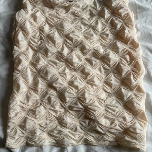  minikjol från MIX - Säljer en minikjol med unik textur och strukturmönster. Kjolen är fodrad på insidan för extra komfort. 