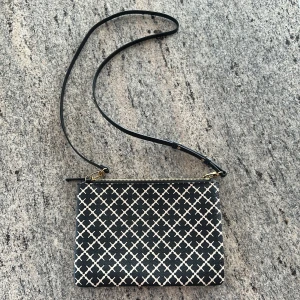 Svartvit axelväska från Malene Birger - Säljer en snygg svartvit axelväska från Malene Birger med klassiskt rutigt mönster och guldfärgad dragkedja. Väskan har justerbar axelrem och är perfekt för att bära det viktigaste. Insidan är fodrad i beige tyg.