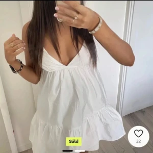 Vit ärmlös klänning - Söt vit klänning med v-ringning och volangdetaljer. Den är ärmlös och har en luftig passform, perfekt för varma dagar. Köpt på Plick men passade tyvärr inte. Finns lite sminkfläckar på insidan men inget man tänker på!