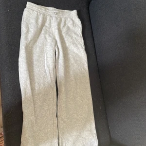 Grå mjukisbyxor från H&M - Superbekväma grå mjukisbyxor från H&M i storlek 158. De har resår i midjan och är gjorda i mjukt bomullsmaterial, perfekta för chill dagar eller när du bara vill vara extra comfy. Klassisk rak passform och enkel stil som funkar till allt.