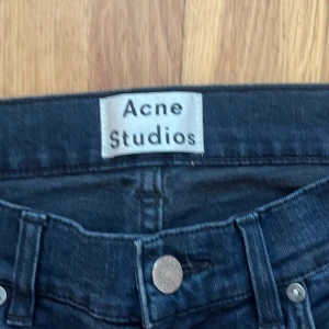 Acne Studios Ace blåsvarta jeans 31/32 - Säljer ett par Acne Studios Ace jeans i blåsvart färg. Modellen är slim och har klassisk femficksdesign, normal midja och raka ben. Materialet är en mix av bomull, polyester och elastan för skön stretch. Perfekta för dig som gillar stilrena och snygga jeans.