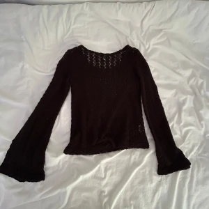 Svart nättopp från Divided - Svart långärmad blus från Divided med genombruten spets och utsvängda ärmar. Toppens material är lätt och luftig, perfekt för att skapa en cool och trendig look. Rund halsringning och figurnära passform som ger en snygg siluett.