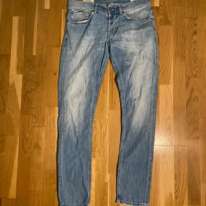 Dondup george - Säljer ett par ljusblå skinny fit jeans från Dondup i storlek 34 och model george. Jeansen har klassisk femficksdesign, slitna detaljer och fransad bakficka för en cool vibe. Materialet är jeans med lätt stretch och passformen är tight hela vägen ner. Notera att byxorna är mycket trasiga och kan ses som ett syprojekt t.ex!