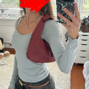 Röd axelväska med knyt - Snygg mörkröd axelväska i skinnimitation och knyt. Fortfarande i nyskick då jag aldrig använt den! Perfekt om du vill ha något snyggt till din outfit eller för vardagligt bruk. ❤️