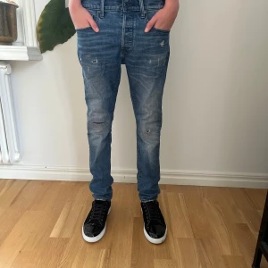 G-Star RAW 3301 Slim jeans blå denim - Snygga blå jeans från G-Star RAW, modell 3301 Slim. Jeansen har en slim passform, klassisk femficksdesign och slitna detaljer på benen för en cool look. Tillverkade i hållbar denim bara att höra av sig för fler frågor! 
