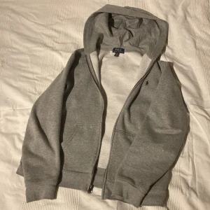 Ralph Lauren zip hoodie - Snygg  grå Ralp Lauren zip hoodie. Skick: 8/10 (litet hål i armbågen, där av priset. Nypris 1100kr Storlek: 170