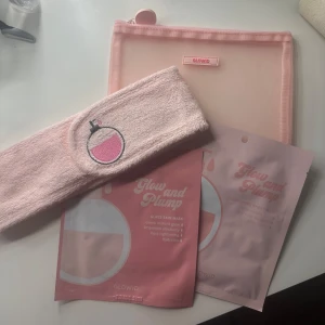Glowid Glow and Plump Sheet Masks - Två rosa Glow and Plump sheet masks från Glowid, en glass skin mask och en nourishing sheet mask. Medföljer gör ett ljusrosa mesh-fodral och ett mjukt, rosa hårband med broderad flaska. Perfekt för en self-care stund och för att boosta huden med glow.