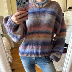 Randig stickad tröja Mads Nørgaard - Supermysig stickad tröja från Mads Nørgaard i coola pastelliga ränder. Färgerna går i blått, lila, beige och rosa. Perfekt för lager på lager under kyliga dagar. Skriv för fler bilder eller frågor🩷