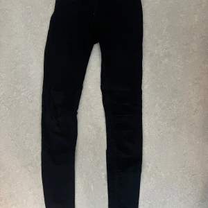 Svarta skinny jeans - Säljer ett par svarta skinny jeans med tajt passform och klassisk design. Perfekta för dig som gillar en stilren look och vill ha ett par byxor som sitter snyggt längs benen. Passar till det mesta och är ett måste i garderoben. Står i storlek (storlek 6= motsvarar 38)