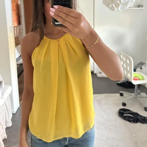 Gul linnetopp med knyt i nacken BikBok - Snygg gul linnetopp från BikBok med tunna axelband och knytning i nacken. Perfekt till fest och sommarkvällar. Köparen betalar för frakten!