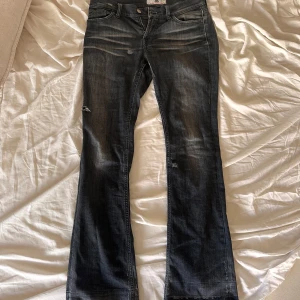 Mörkblå bootcut jeans Fornarina - Snygga svarta jeans från Fornarina med bootcut passform och slitna detaljer. Jeansen har klassisk femficksdesign, låg midja och är tillverkade i  bomullsdenim för en bekväm känsla. Perfekta för dig som gillar en avslappnad men trendig look. Dom kosta 1500kr nya🫰🏼💞