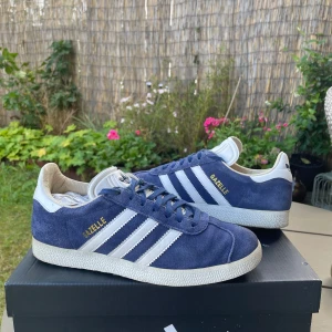 Adidas Gazelle blå mockasneakers - Hej! Säljer nu ett par Adidas Gazelle i strl 37 och 1/3 men passar även som 37,5! Använda i ett sparsamt/varsamt skick! Perfekt sko nu när man kommer tillbaks till skola och jobb! Nypris-1300kr!