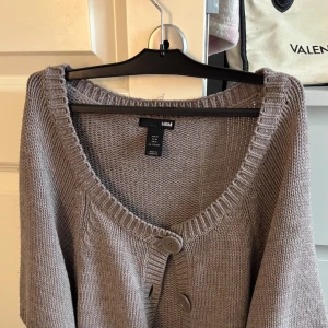 Brun stickad kofta från H&M - Brun stickad kofta från hm. Passar perfekt till hösten. Säljer pågrund av att den är för stor för mig som vanligtvis är en xs