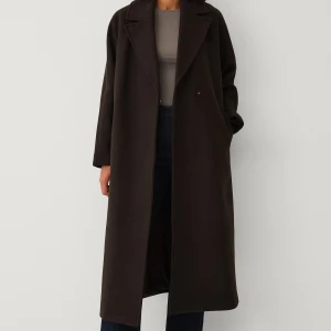 Mörkbrun kappa med bälte från Ellos - Snygg mörkbrun kappa från Ellos. Helt ny med prislapp kvar. Den är slutsåld på hemsidan.