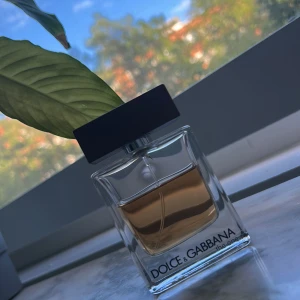 Dolce & Gabbana The One EdT Ungefär 30ml kvar  - Säljer en Dolce & Gabbana The One Eau de Toilette, 50 ml. Flaskan är stilren och rektangulär i genomskinligt glas med brunt fyrkantigt lock. Parfymen har en varm bärnstensfärgad vätska och klassisk logga framtill. Ungefär 30 ml kvar. Har haft den länge 