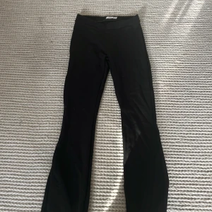 Svarta bootcut leggings från Name It - Svarta leggings från Name It i storlek 152, med bootcut-snitt som ger en snygg och trendig siluett. Mjukt och stretchigt material som sitter skönt och följer kroppen. Perfekta för dig som gillar en stilren look med lite extra edge.