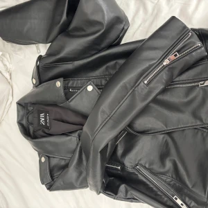 Svart skinnjacka från Zara - Snygg svart skinnjacka från Zara. Aldrig använd. Frakt tillkommer
