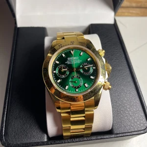 Seiko Daytona ”John Mayer” Mod - Nybyggd Seiko Daytona ”John mayer” mod  Specifikationer: Storlek: 39mm Urverk: VK63 Kronograf (Batteri) Material: 904L Rostfritt stål Glas: Sapphire Glas Armband: Viklås och justerbart Tavla: Grön Urtavla med små röda detaljer Krona: Screw down Vattentålighet: 30 Meter  I min åsikt bland den snyggare klockorna som finns. Hör av er i DM vid intresse!