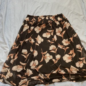 Blommig svart kjol från KAFFE - Vintage svart midi kjol från KAFFE med vita och ljusbruna blommor. Kjolen har resår i midjan för en skön passform och är tillverkad i ett lätt, flowy material. Det står inte storleken men skulle säga at den är cirka S. Säljer då den inte kommer till användning och behövde rensa garderoben.💞💞