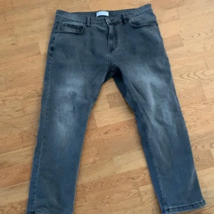 Pier one grå jeans straight fit - Säljer ett par grå jeans från pier one med snyggt tvättad look och klassiska fem fickor. Modellen har tapered fit med smalare ben och normal midja. Jeansen är tillverkade i mjukt denim-material och har dragkedja i gylfen. Perfekta för en chill och stilren vibe.
