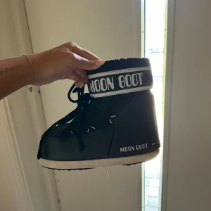Svarta Moon Boots - Svarta Moon Boots med vit sula. Skorna har snörning framtill och är fodrade för extra värme. Använda få gånger! Storlek 40💞