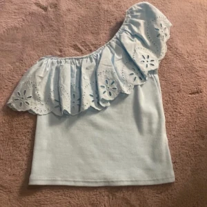 Ljusblå volangtopp - Supersöt ljusblå topp som man även kan ha offshoulder. Den ser ljusare ut än va den är på första bilden, den är som färgen på de andra två bilderna. Den är i storlek 152 men är som storlek XS