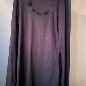 Svart långärmad topp med spetsdetaljer - Säljer en svart långärmad topp med fina spetsdetaljer både vid halsringningen och vid ärmsluten. Perfekt för dig som gillar en enkel men ändå lite extra look. Mjuk och skön att ha på sig.